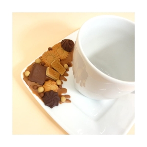 Filiżanka i talerzyk zdobiony słodkościami